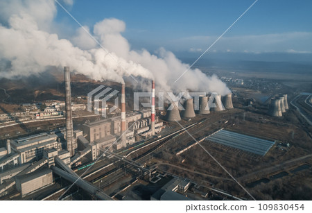 Aerial view of tall chimney pipes with grey smoke from coal power plant. Production of electricity with fossil fuel. Ecology and pollution of nature. Aerial view of tall chimney pipes with grey smoke from coal power plant. Production of electricity with fossil fuel. Ecology and pollution of nature. 109830454