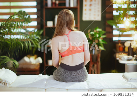 teen girl in therapist cabinet sitting on massage table teen girl in therapist cabinet sitting on massage table 109831334
