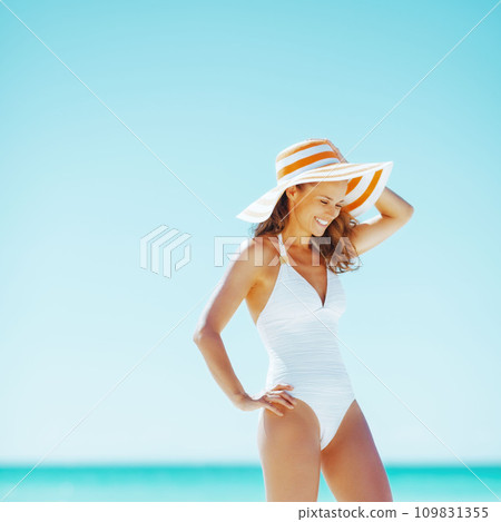 smiling young woman in hat on beach smiling young woman in hat on beach 109831355