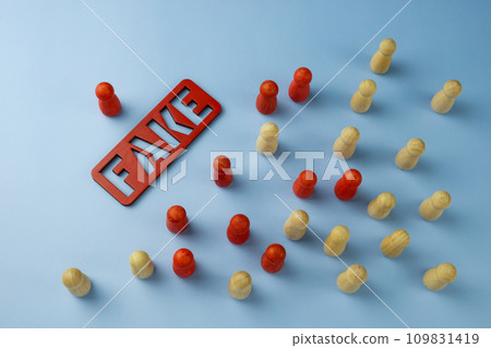 The inscription fake and figures as symbols of the spread of misinformation and propaganda. 109831419