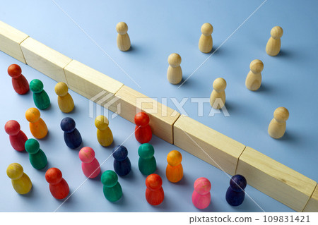 Diversity and immigration. Multi-colored figures are separated from wooden ones by a wall. 109831421