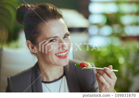 happy modern woman employee in modern green office eating salad happy modern woman employee in modern green office eating salad 109831670