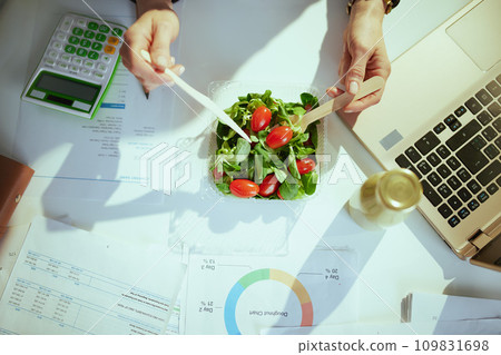 business owner woman in green office eating salad 109831698
