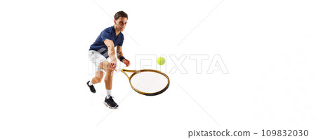 Young athletic man, tennis player in motion, hitting ball with racket isolated over white background. Dynamic game 109832030