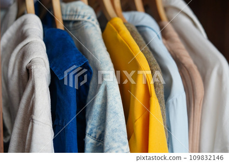 Clothing hanging on a clothing rack in a shop or home closet Clothing hanging on a clothing rack in a shop or home closet 109832146