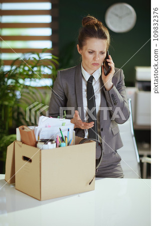 stressed woman worker in green office talking on phone stressed woman worker in green office talking on phone 109832376