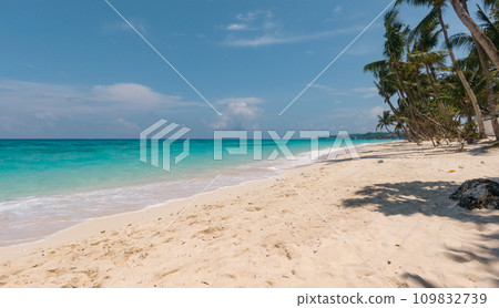 Sandy tropical beach with palm trees and blue sea against the sky. Summer and travel vacation concept. Boracay, Philippines Sandy tropical beach with palm trees and blue sea against the sky. Summer and travel vacation concept. Boracay, Philippines 109832739