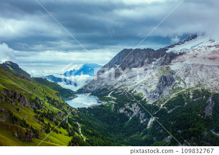 landscape with mountains, hills, Fedaia lake, clouds and forest 109832767
