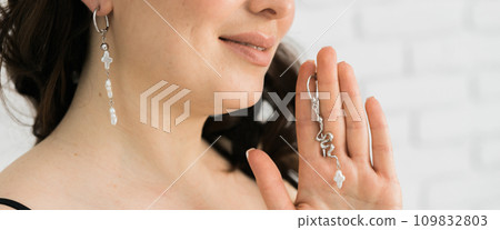 Banner Detail of young woman wearing beautiful luxury earring. Handmade jewellery and accessories 109832803