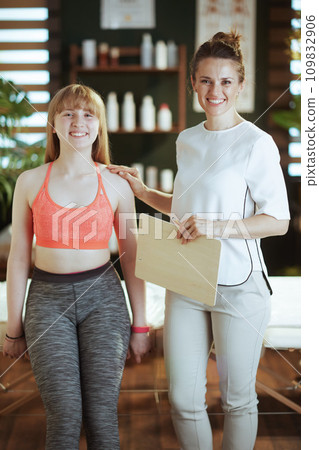 female therapist in massage cabinet conducting examination female therapist in massage cabinet conducting examination 109832906