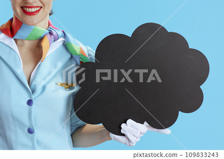 Female flight attendant on blue showing blank cloud shape board 109833243
