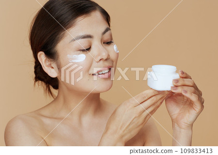 young asian woman with facial cream jar young asian woman with facial cream jar 109833413