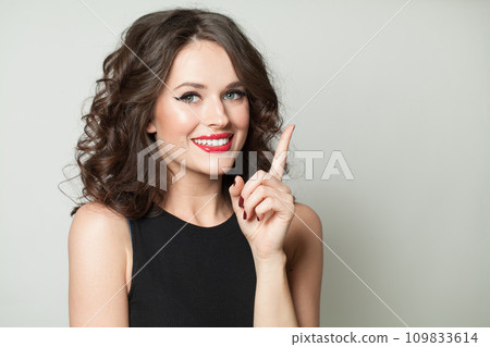 Woman pointing finger up. Young glamorous fashionable brunette model woman  109833614