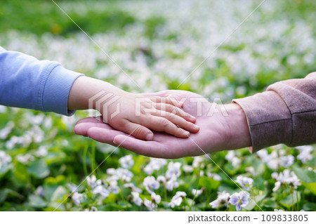 Father holds daughter by the hand close-up. nature background, Support and family love 109833805