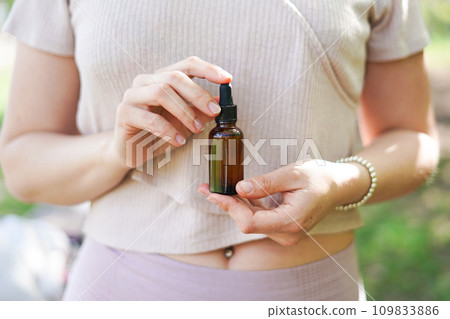 Woman holding glass bottle with spa cosmetic oil. salon therapy, natural eco body care products 109833886