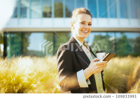 happy female worker in business district using smartphone happy female worker in business district using smartphone 109833991