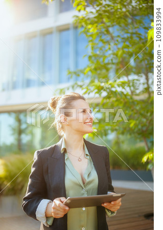 happy woman worker near office building using digital tablet happy woman worker near office building using digital tablet 109833994