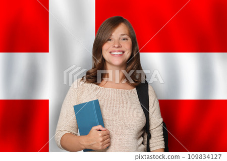 Friendly woman student against Danish flag background. Travel, education  109834127