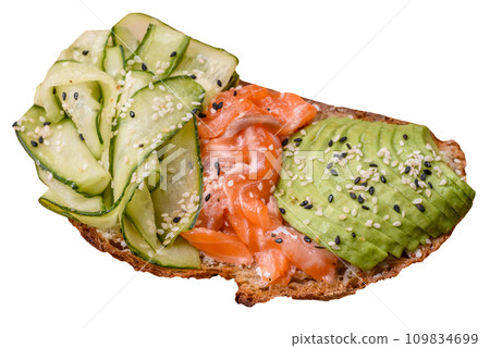Delicious brown bread toast with salmon, avocado, cucumber and sesame seeds Delicious brown bread toast with salmon, avocado, cucumber and sesame seeds 109834699