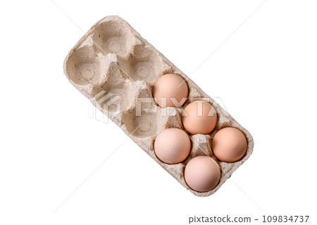 Fresh raw chicken eggs in beige color in a cardboard tray Fresh raw chicken eggs in beige color in a cardboard tray 109834737
