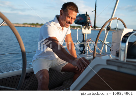 Man in white clothes sailing on a yacht Man in white clothes sailing on a yacht 109834901