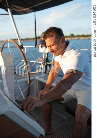 Man in white clothes sailing on a yacht Man in white clothes sailing on a yacht 109834903