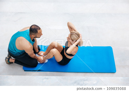 Female training abdominal muscles with her friend support. Female training abdominal muscles with her friend support. 109835088
