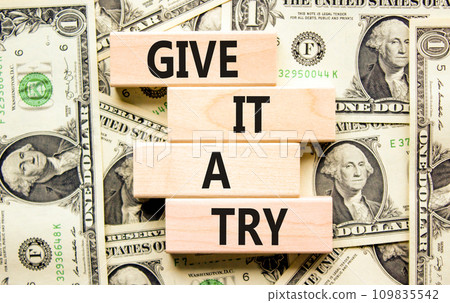 Give it a try symbol. Concept word Give it a try on beautiful wooden block. Dollar bills. Beautiful background from dollar bills. Business give it a try concept. Copy space. 109835542