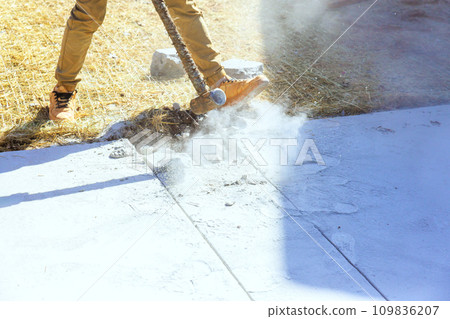 Worker demolishes concrete old driveway using hammer on construction site 109836207