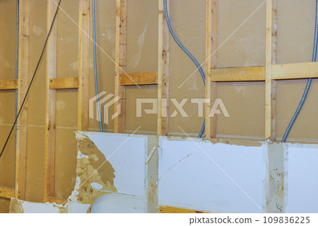 During reconstruction of house removal of old, damaged plasterboard drywall is conducted 109836225