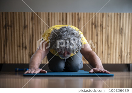 Senior man practicing yoga or pilates making a childs pose 109836689