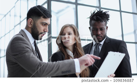 Portrait of confident young business people looking at a folder with a contract Portrait of confident young business people looking at a folder with a contract 109836887
