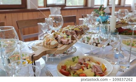 Business lunch. A beautiful festive table covered with a variety of food. Food and drinks on the festive table in the restaurant. Beautifully decorated banquet table with appetizers. Business lunch. A beautiful festive table covered with a variety of food. Food and drinks on the festive table in the restaurant. Beautifully decorated banquet table with appetizers. 109837262