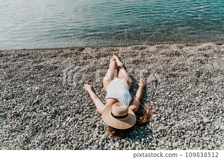 Woman white bikini beach tan. Happy woman in swimwear and hat on vacation. Summer travel holidays vacation on the sea Woman white bikini beach tan. Happy woman in swimwear and hat on vacation. Summer travel holidays vacation on the sea 109838512