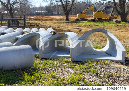 At construction site, concrete drainage sewage stormwater pipes are stacked to installation 109840639