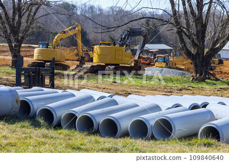 Are awaiting installation of stacked concrete drainage sewage storm water pipes at construction site 109840640