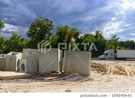 At construction site, concrete drainage sewage storm water manhole stacked are awaiting preparation to installation. 109840643