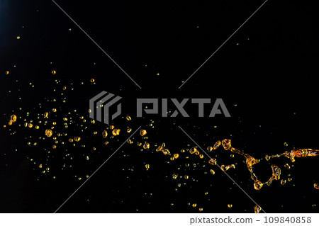 Orange, lemon juice or oil lubricant splash, liquid gold yellow drink drops. Fruit beverage water elements in line form . Fresh splashing and flowing jets, black background isolated freeze motion 109840858