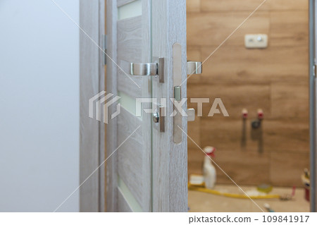 Handyman installed lock handles at wooden door Handyman installed lock handles at wooden door 109841917