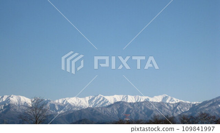 冬日陽光明媚的日子裡，雪山和藍天 109841997