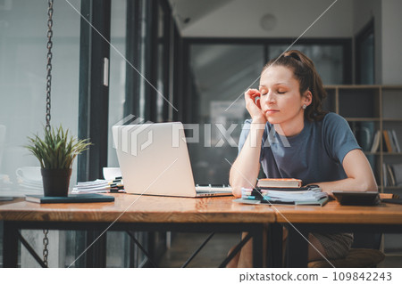 Overworked businesswoman suffering from headache and thinking how to end work. Overworked businesswoman suffering from headache and thinking how to end work. 109842243