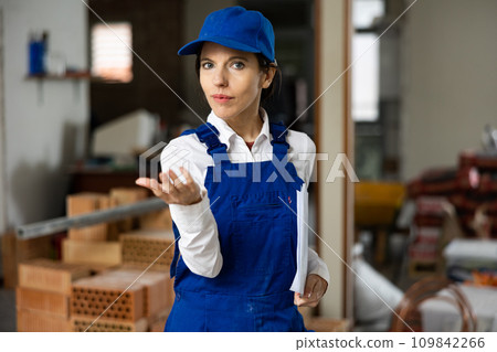 Female contractor showing customer amount of work done at construction site 109842266