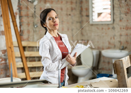 Motivated woman making notes on home space planning during renovation 109842269