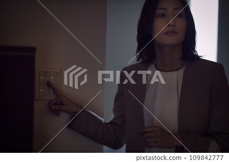 Night routine of a business woman who turns on the light in the room Night routine of a business woman who turns on the light in the room 109842777