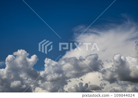 Blue sky with white cumulus clouds illuminated by daylight Blue sky with white cumulus clouds illuminated by daylight 109844024
