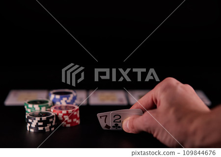 Dealer or croupier shuffles poker cards in a casino on the background of a table, chips. Concept of poker game, game business. Playing for money, a big win, a jackpot, gambling, a desire to get rich. Dealer or croupier shuffles poker cards in a casino on the background of a table, chips. Concept of poker game, game business. Playing for money, a big win, a jackpot, gambling, a desire to get rich. 109844676