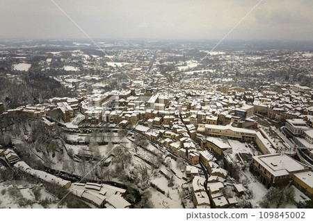 Aerial winter landscape of dense historic center of Thiers town in Puy-de-Dome department, Auvergne-Rhone-Alpes region in France. Rooftops of old buildings and narrow streets at snowfall 109845002