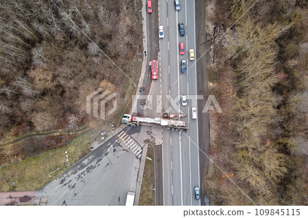 Aerial view of road accident with overturned truck blocking traffic Aerial view of road accident with overturned truck blocking traffic 109845115