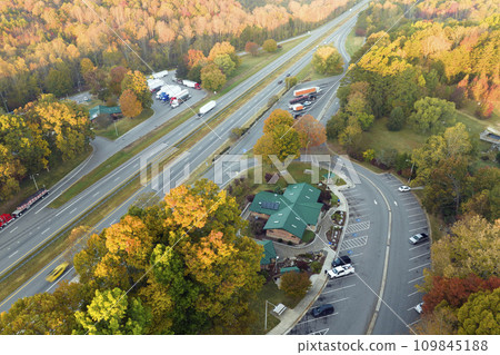 Large truck stop with resting area near busy american interstate freeway with fast driving cars and trucks. Recreational parking place during interstate travel 109845188
