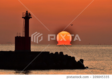 Bright red Daruma sunrise and lighthouse Bright red Daruma sunrise and lighthouse 109845335